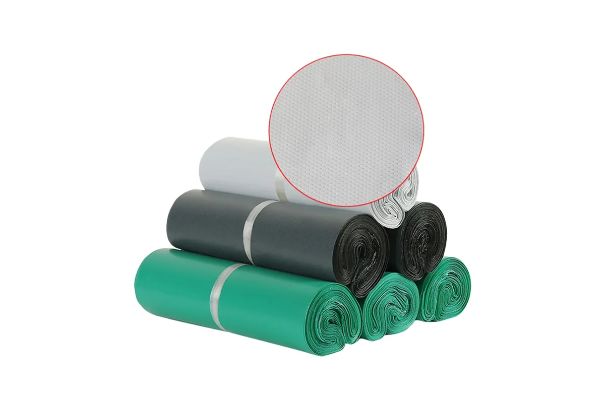 Embossed courier bag rolls in white, grey, black and green, with a close-up of the embossed texture
