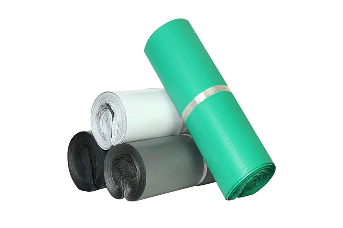 Rolls of green, white, grey and black embossed courier bags