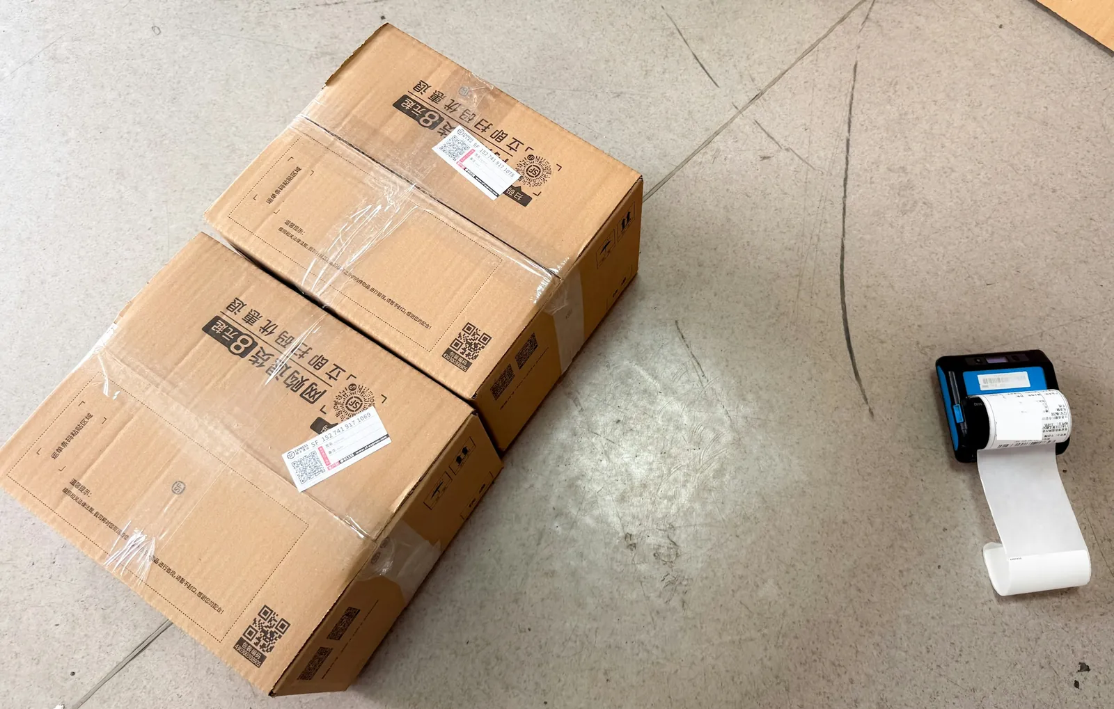 Thermal label printer next to labelled shipping cartons