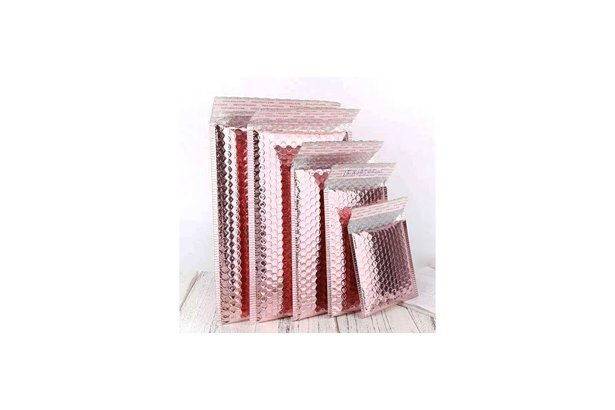 Pink pearlescent bubble mailers in five sizes standing in a row